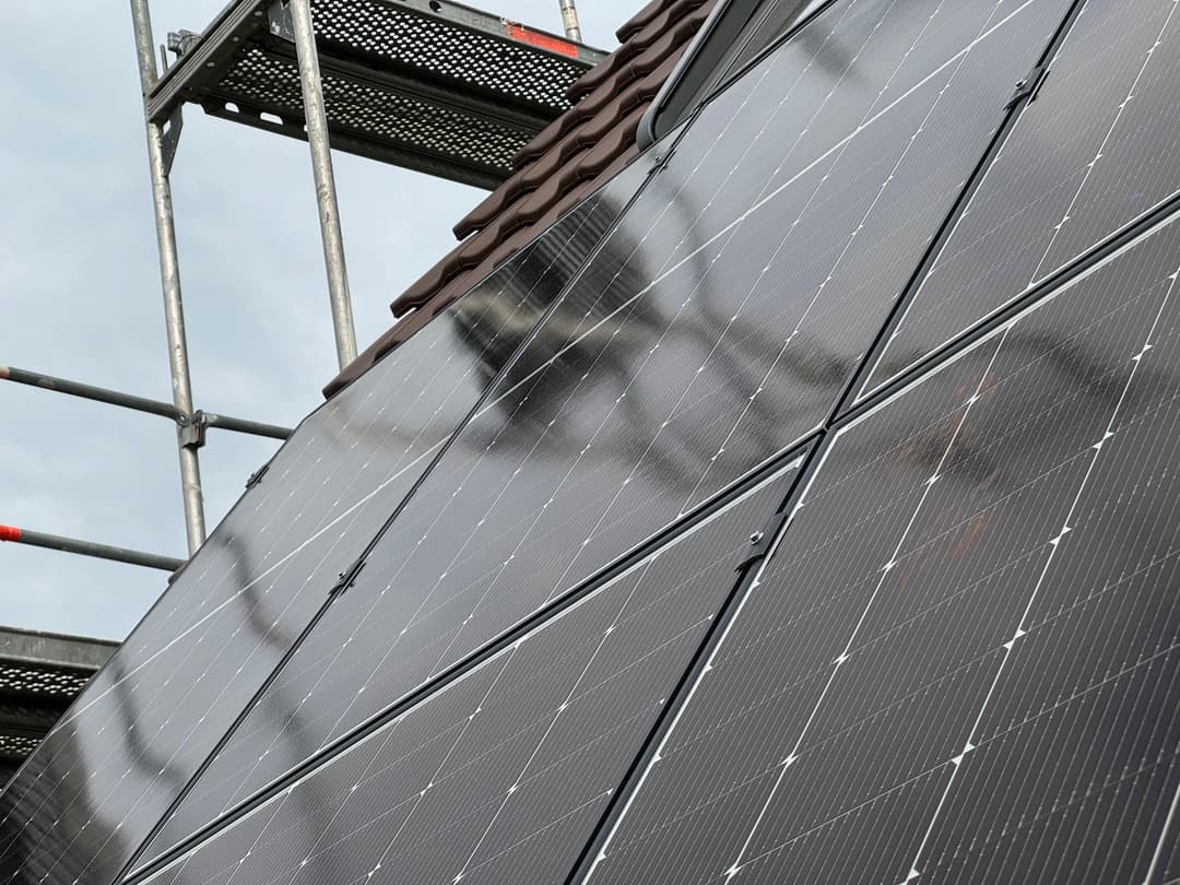 PV-Anlage auf einem Dach mit Gerüst im Hintergrund