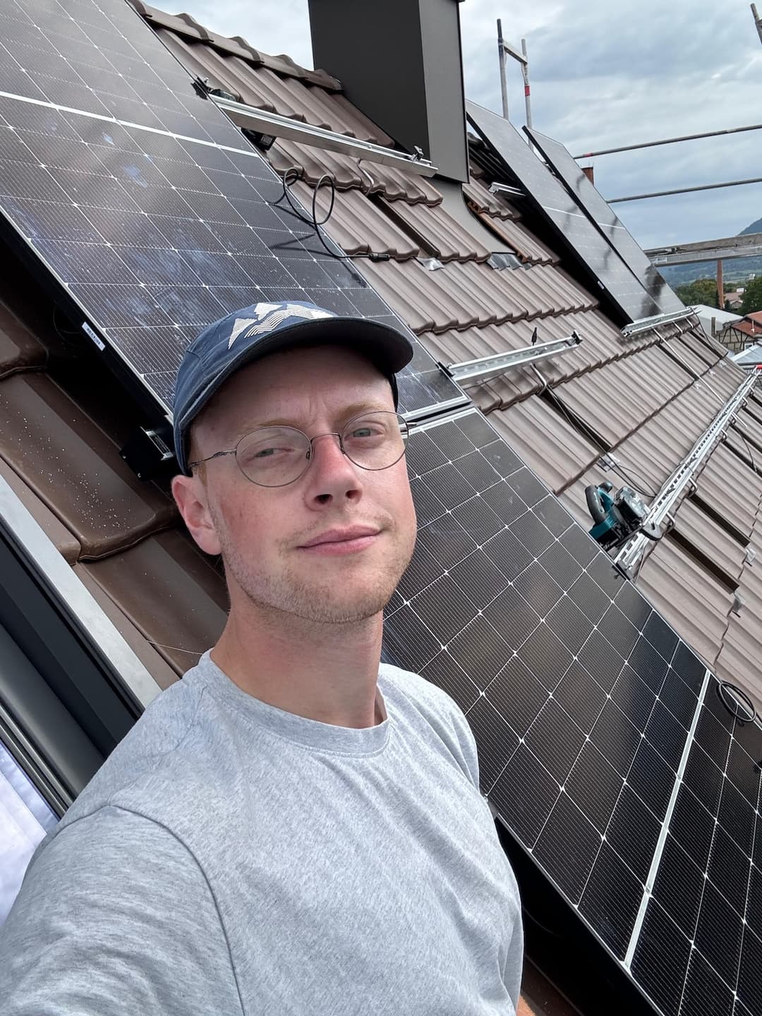 Inhaber von Elektro Gadge auf dem Dach neben einer PV-Anlage